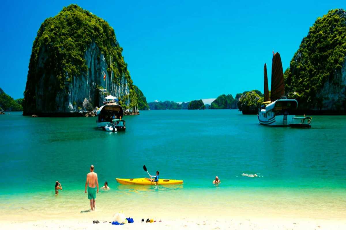 Limestone Islands and Boats in Halong Bay near Soi Sim Boats sailing near towering limestone islands in Halong Bay close to Soi Sim Island