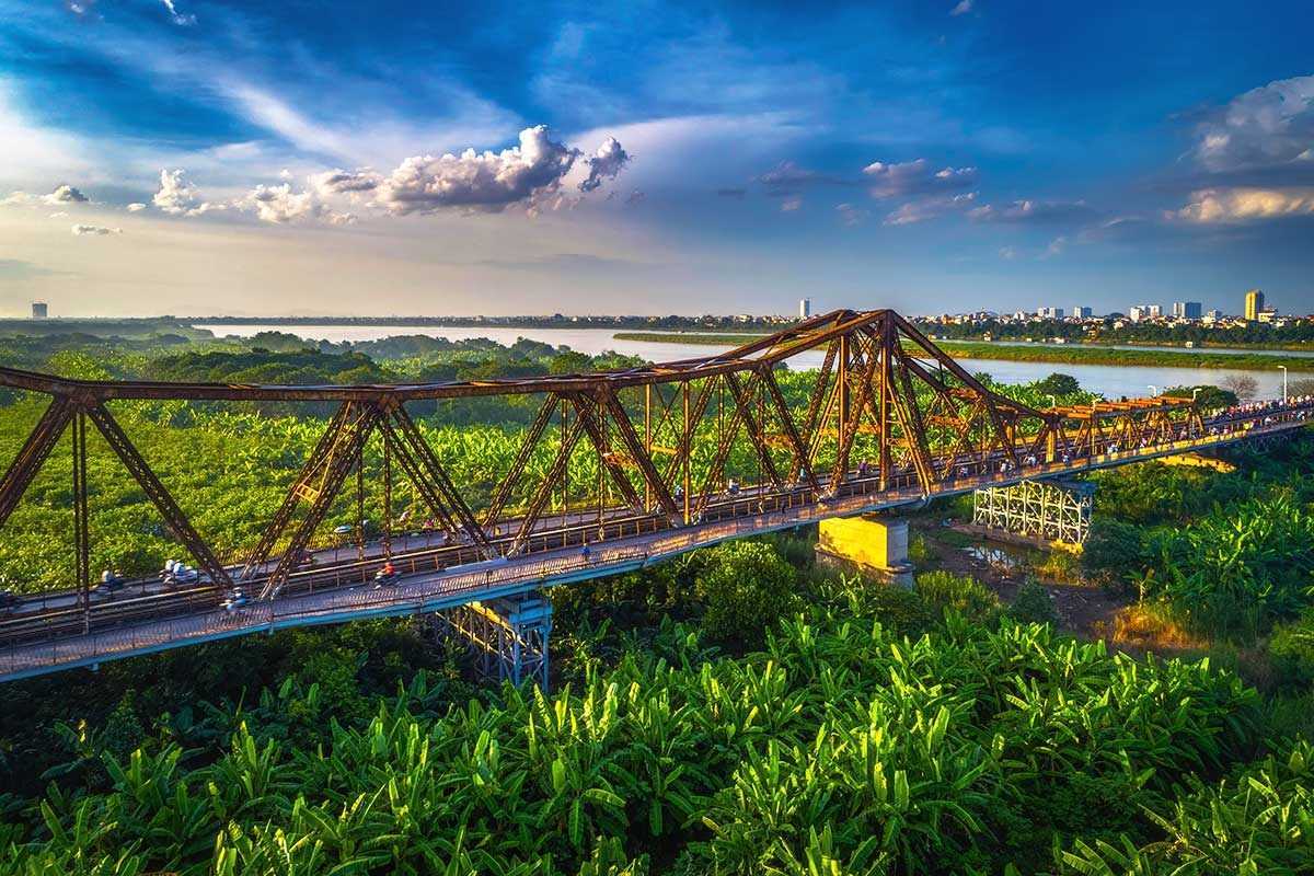 Long Bien Bridge Over Red River Vietnam Daytime Daytime view of Long Bien Bridge spanning the Red River Vietnam with blue skies