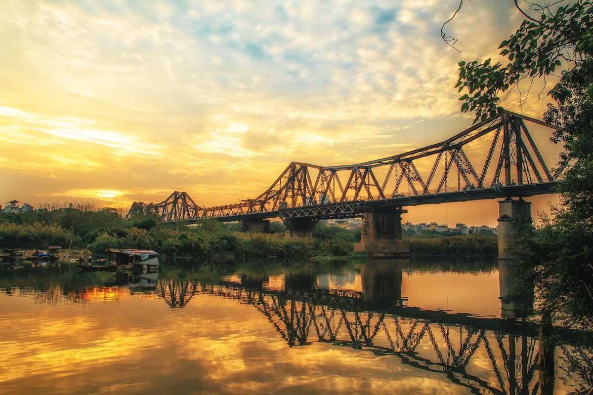 Long Bien Bridge Hanoi Evening River Fishing Fishermen casting nets on the river near Long Bien Bridge during evening light