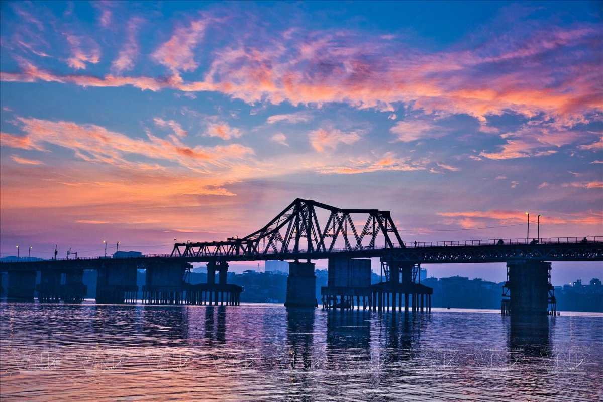 Long Bien Bridge at Sunset Over the Red River Vietnam The historic Long Bien Bridge silhouetted at sunset over the Red River Vietnam