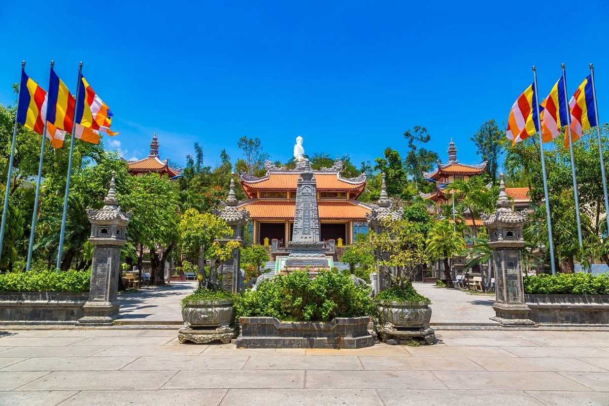 Main Courtyard of Long Son Pagoda Courtyard of Long Son Pagoda with flags and stone pillars under blue sky in Nha Trang.