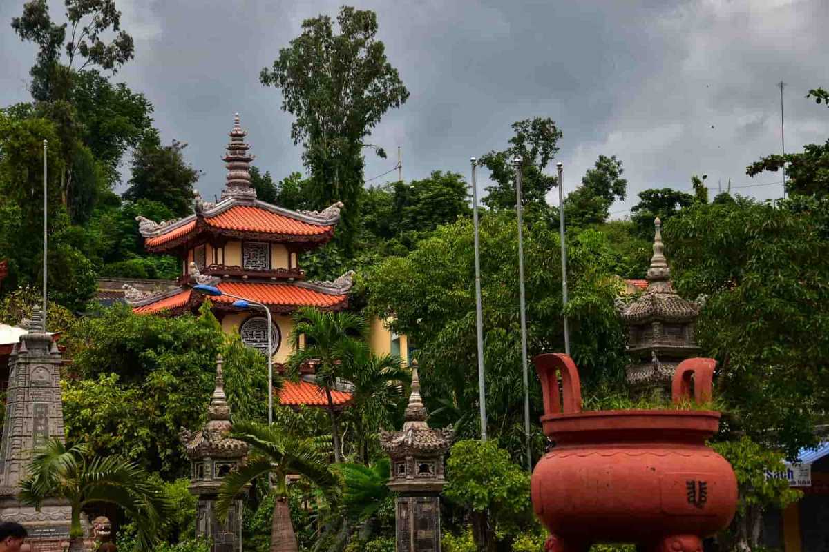 Pagoda Tower Surrounded by Trees Red-tiled pagoda tower surrounded by dense greenery at Long Son Pagoda in Nha Trang.