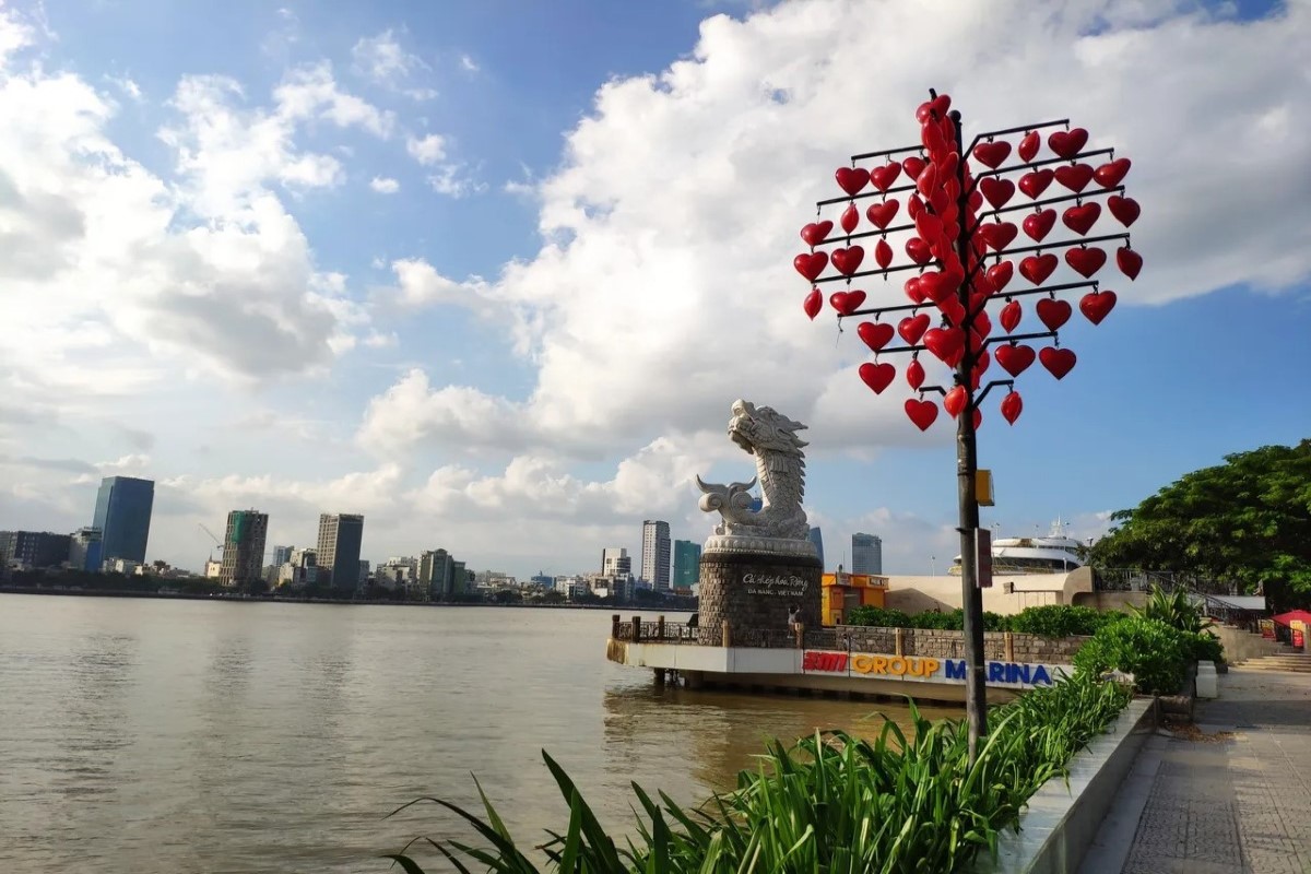 View of the Love Lock Bridge Da Nang, featuring the Carp Dragon statue overlooking the Han River, with a scenic city backdrop.