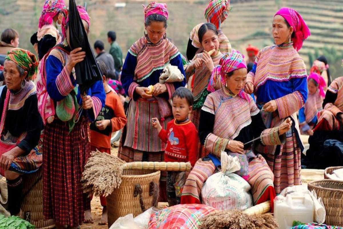 Lung Khau Nhin Market highland women and children in daily trade Women and children of ethnic communities gather around sacks of grain and textiles at Lung Khau Nhin Market in Lao Cai hills