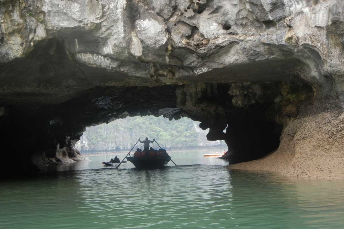 Luon Cave Halong Bay Bamboo Boat Silhouette at Cave Exit Silhouetted bamboo boats exiting limestone cave of Luon Cave surrounded by scenic cliffs