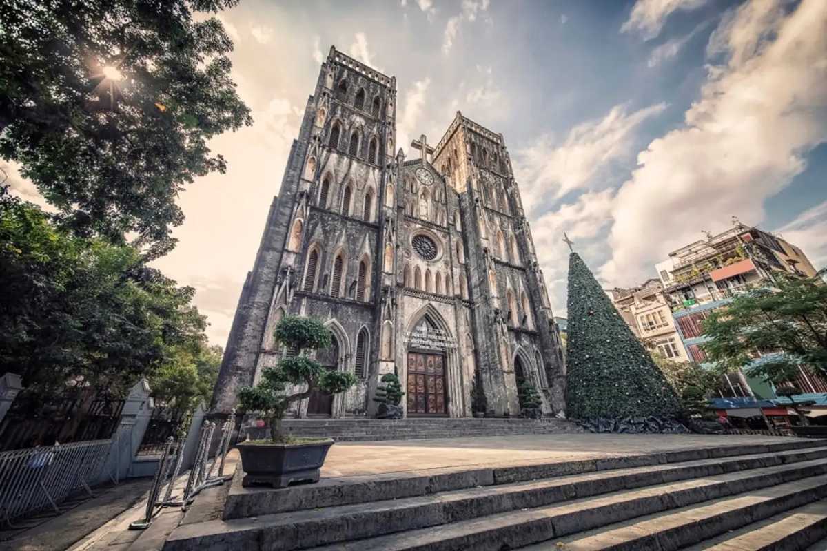 Main Entrance of St. Joseph’s Cathedral Hanoi Wide-angle photo of the cathedral’s front entrance with Gothic architecture and clear weather