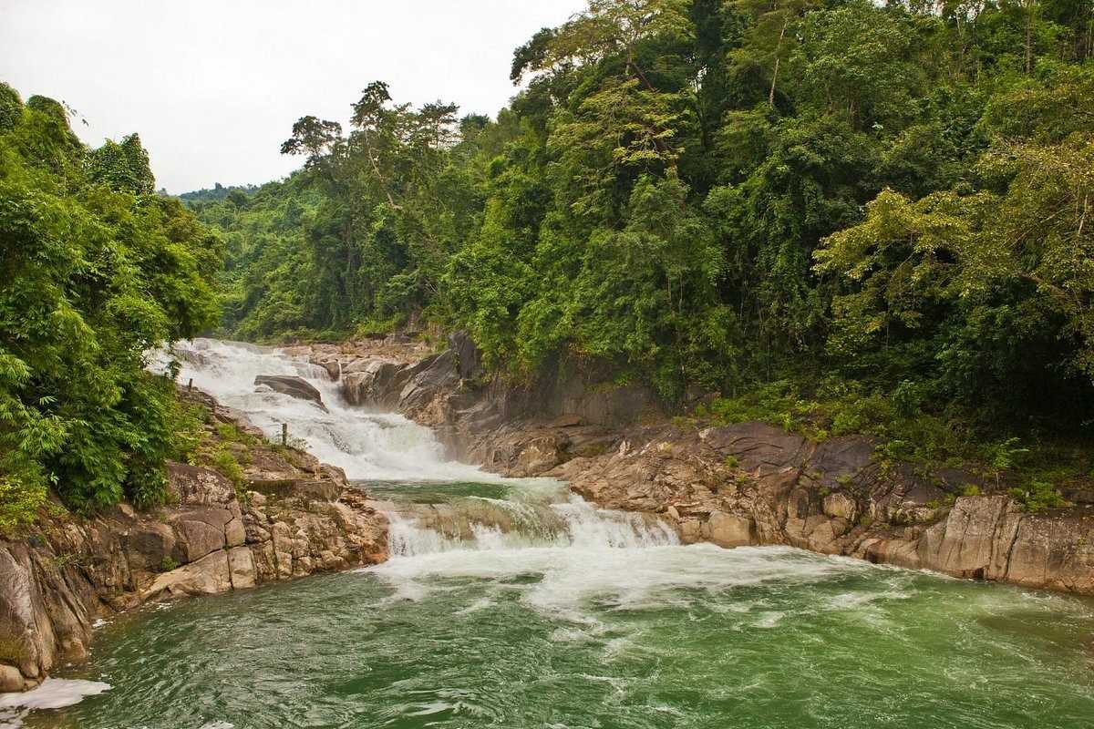 Yang Bay main waterfall near Crocodile Farm Wide jungle waterfall near Crocodile Farm Yang Bay with rock formations and flowing water.