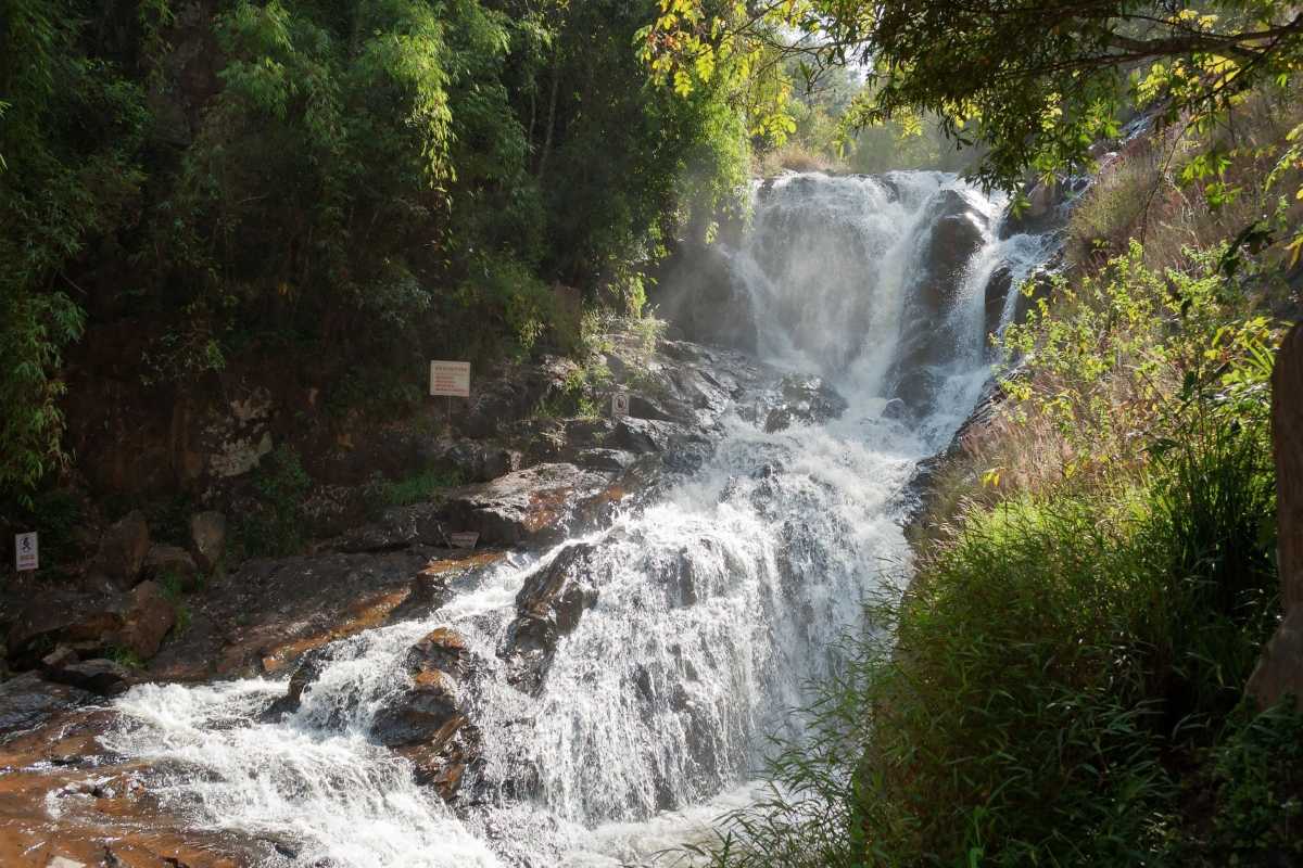 Majestic Cascades of Datanla Waterfalls in Da Lat Flowing water cascading over rugged rocks at Datanla Waterfalls framed by green vegetation