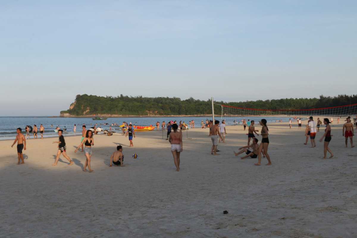 Crowded Beach Scene with Water Sports at Minh Chau Many people enjoying water sports and beach activities at Minh Chau Beach, Quan Lan Island