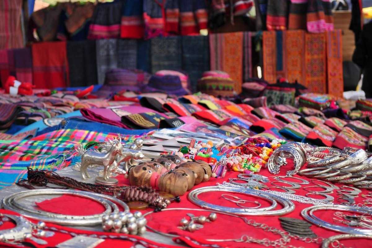 Muong Hum Market Sapa handicrafts silver jewelry textiles Muong Hum Market Sapa displays handmade jewelry, silver ornaments, and colorful ethnic textiles at craft stalls.