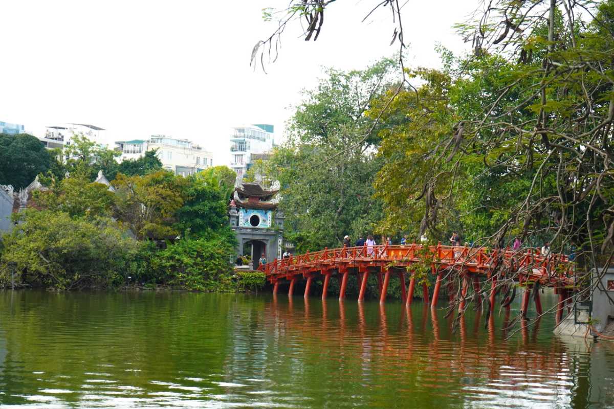 Ngoc Son Temple pathway under trees Tree-lined pathway leading to Ngoc Son Temple entrance with visitors walking along