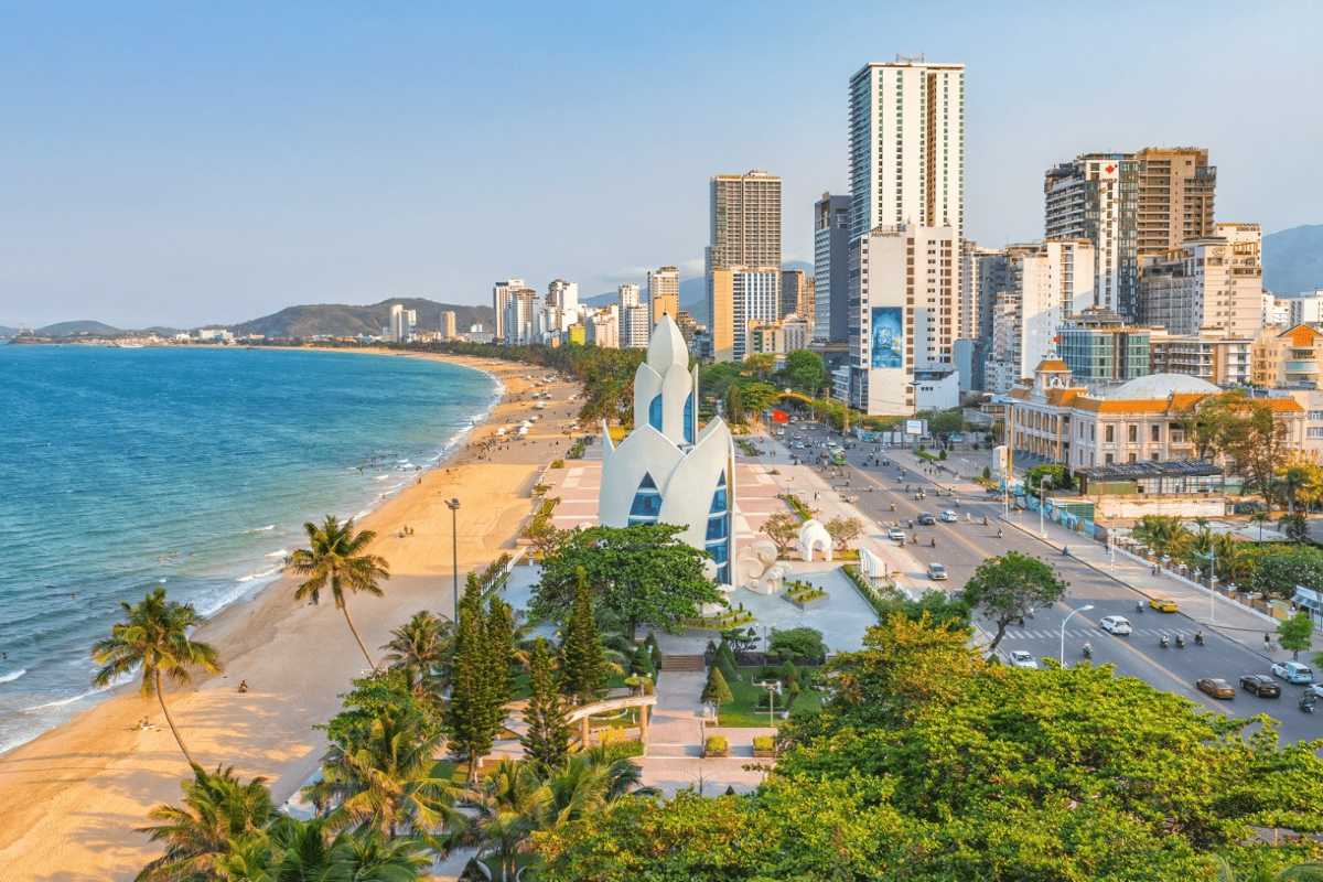 Modern Nha Trang by the coast White sand beach of Nha Trang with modern towers and clear afternoon skies