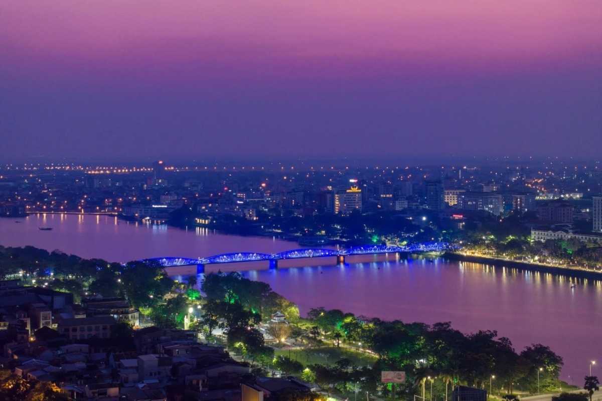Night View of Perfume River and Hue City Skyline Nighttime view of the Perfume River illuminated by city lights with the Hue City skyline in the background.