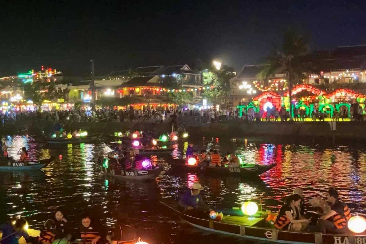 Nighttime Lantern Boats on Hoai River at Hoi An Night Market Lantern-lit wooden boats filled with visitors floating on Hoai River during Hoi An Night Market