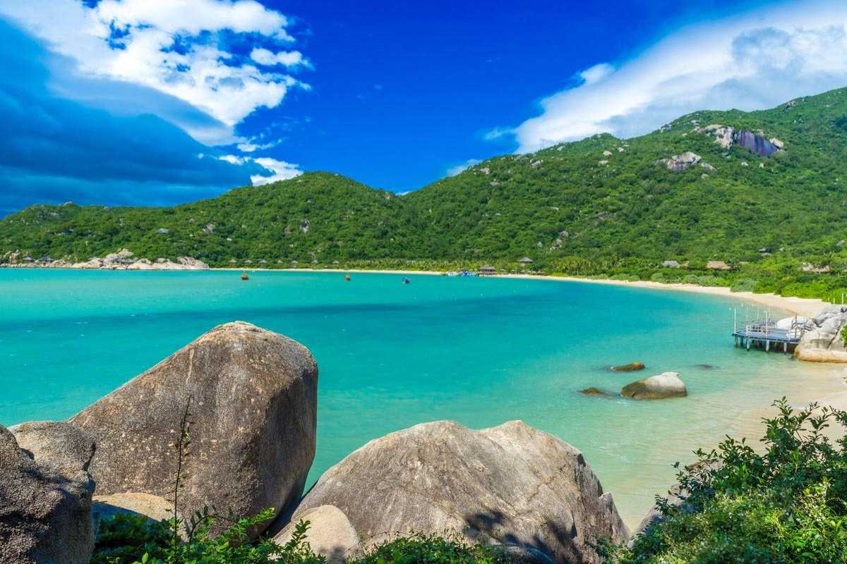 Scenic view of turquoise waters and green hills at Ninh Van Bay beach.