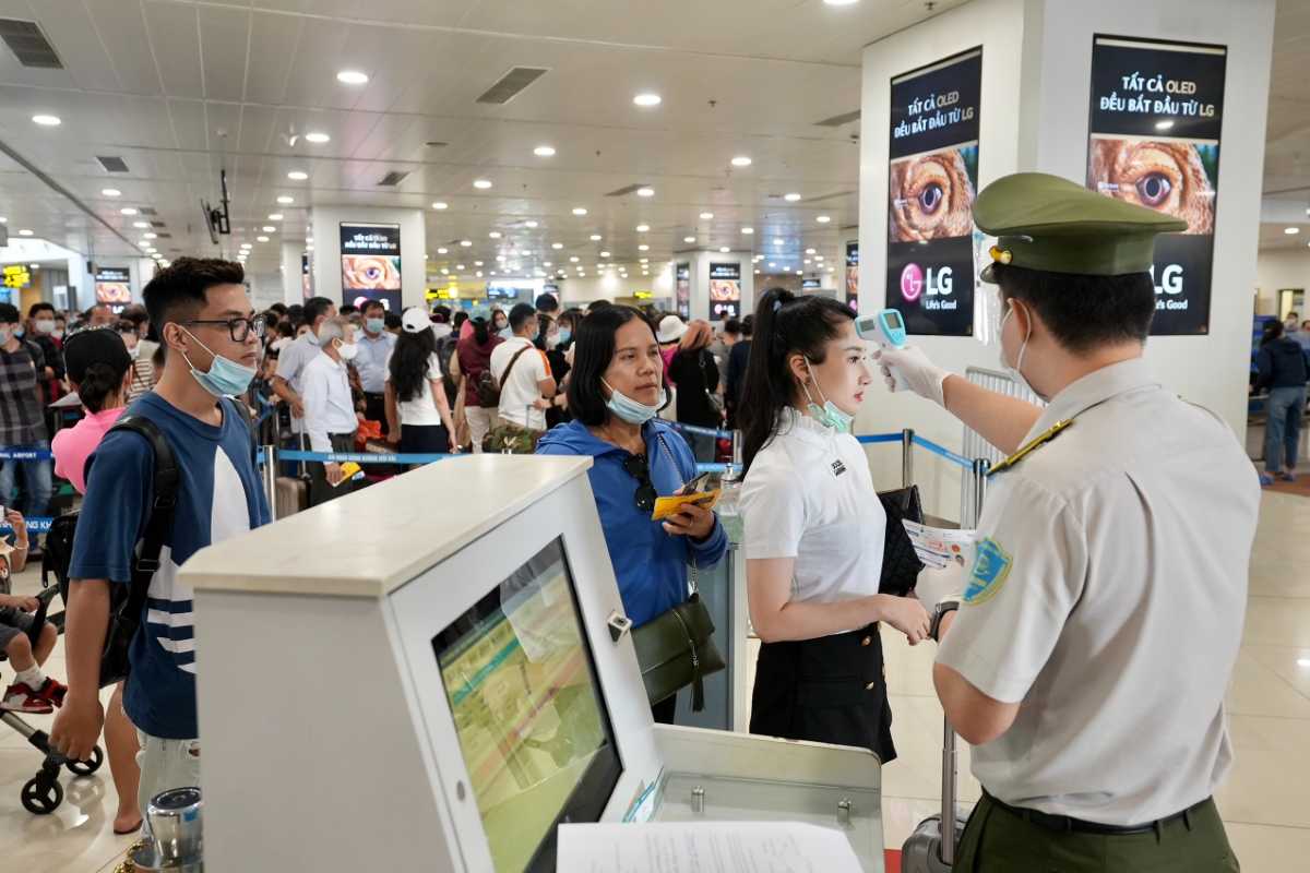 Passenger Drop-off Area at Noi Bai International Airport Passenger drop-off zone under terminal canopy at Noi Bai International Airport with cars and travelers