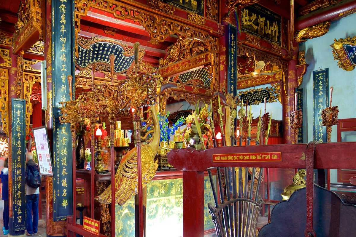Ornate Interior of Quan Thanh Temple Ornate interior with intricate wooden carvings and altars inside Quan Thanh Temple