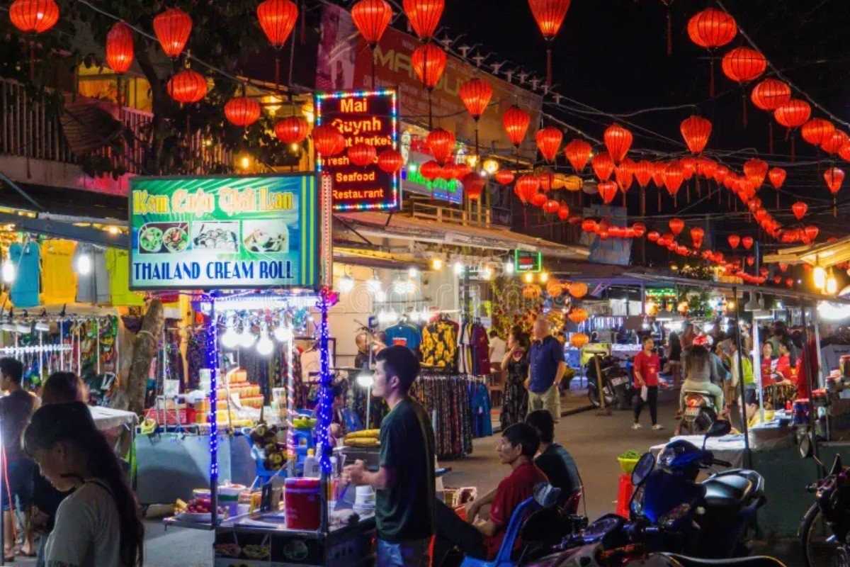 Packed Night Market with Various Food Stalls Visitors exploring multiple food stalls under red lanterns at Duong Dong Night Market