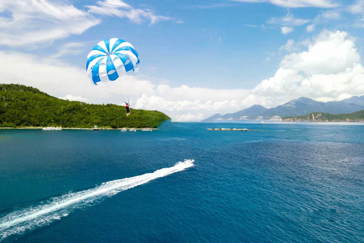 Parasailing over Nha Trang Bay blue waters Parasailing adventure over the clear blue waters of Nha Trang Bay with islands in the background