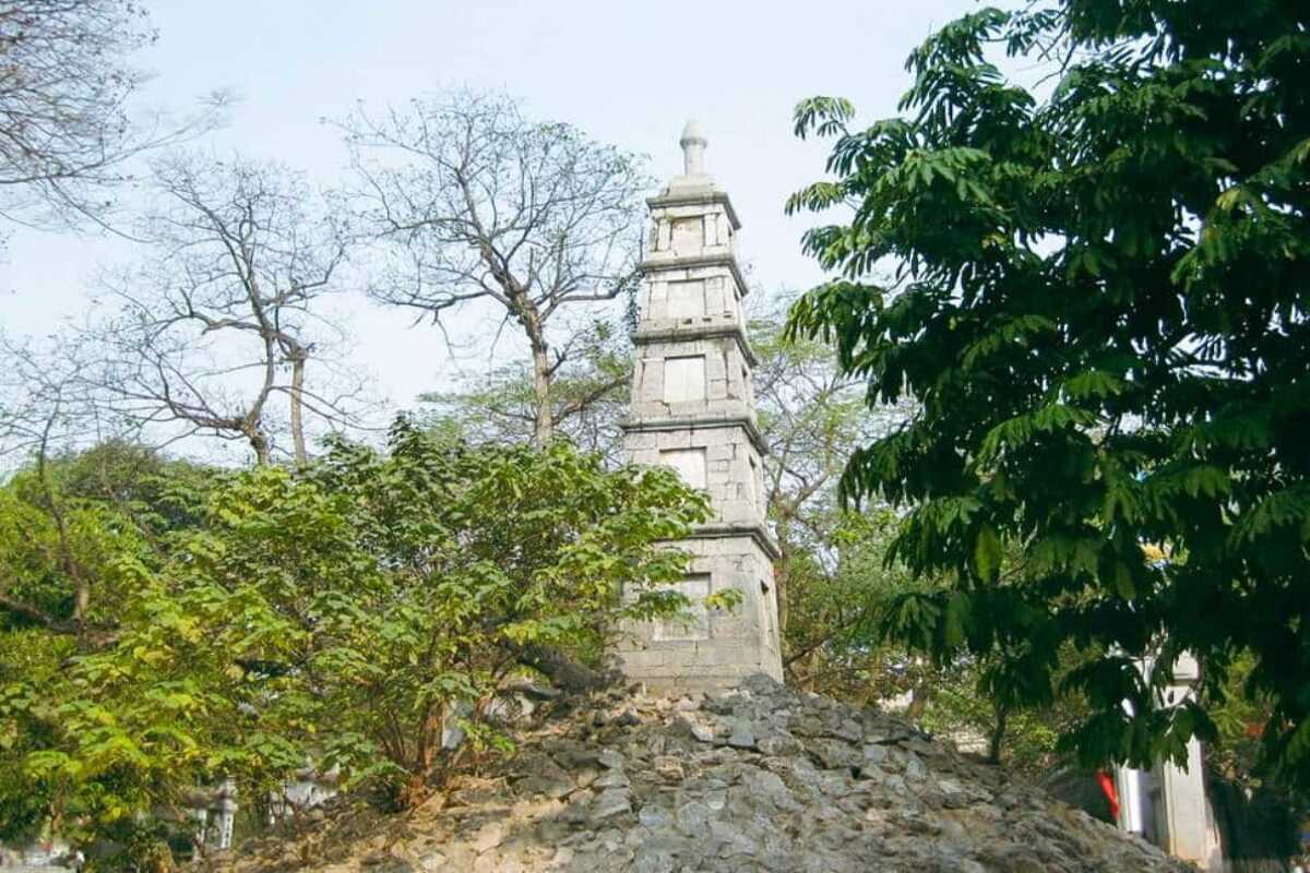 Pen Tower Surrounded by Trees and Historic Gate Pen Tower seen through historic gate pillars with lush trees at Hoan Kiem Lake