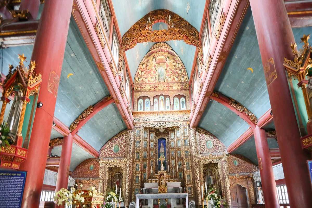 Phat Diem Cathedral Ninh Binh ornate altar and blue ceiling Intricate altar with gold detail and blue painted ceiling inside Phat Diem Cathedral Ninh Binh