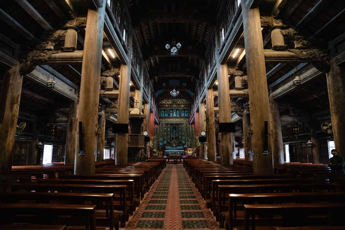 Phat Diem Cathedral Ninh Binh stone interior and altar Inside Phat Diem Cathedral Ninh Binh with stone pillars, wooden beams, and ornate altar