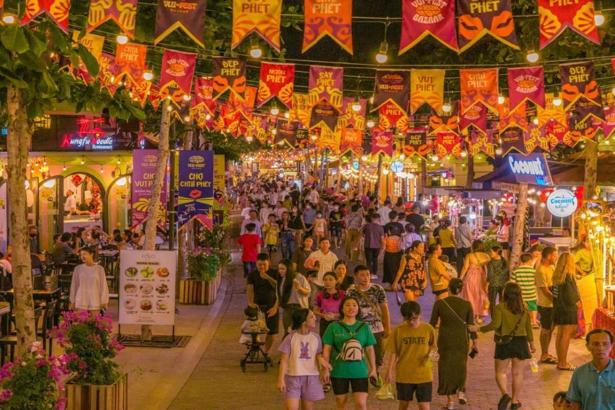 Busy evening scene at Phu Quoc Night Market with colorful lanterns and crowds enjoying food and shopping