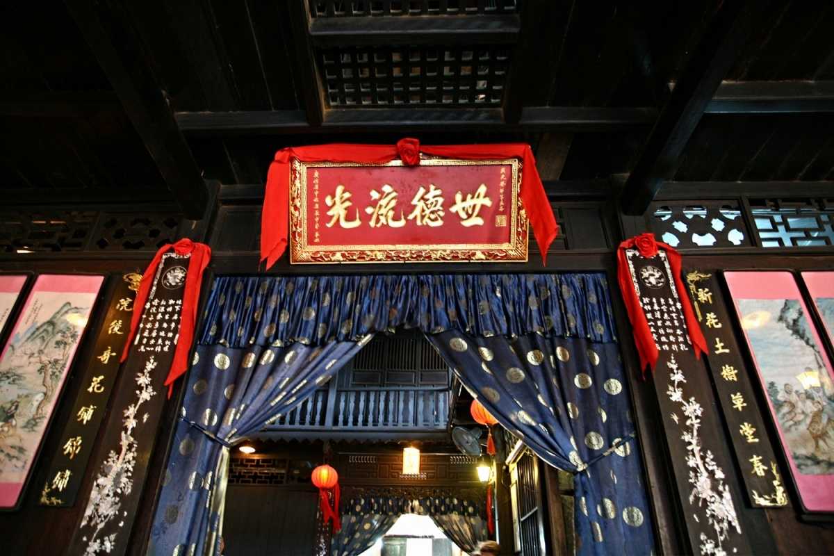 Main Entrance Curtain and Sign – Phung Hung Ancient House Decorative blue silk curtain and red signage at the main entrance of Phung Hung Ancient House with Chinese calligraphy.