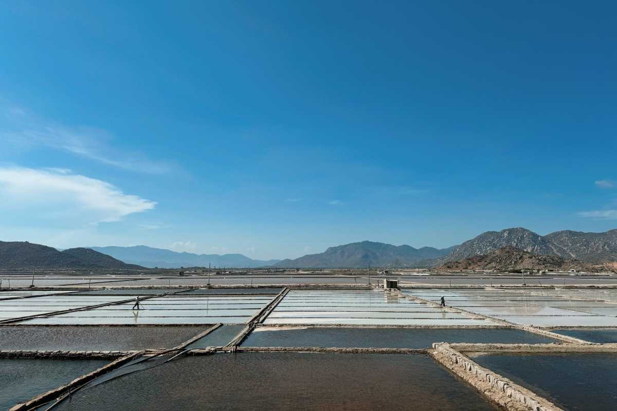 Panoramic View of Salt Ponds at Phuong Cuu Salt Field Wide view of salt evaporation ponds and workers at Phuong Cuu Salt Field