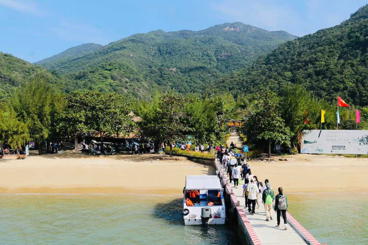 Pier and Visitors at Orchid Stream Island Nha Trang Pier with tourists walking towards the island shore surrounded by tropical trees
