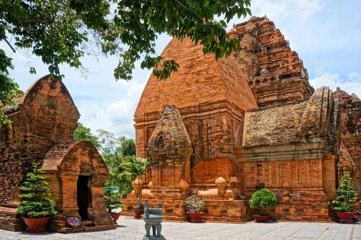 Cham temples at Ponagar Tower complex Red-brick Cham temples at Ponagar Cham Towers complex with carved details and surrounding trees in Nha Trang