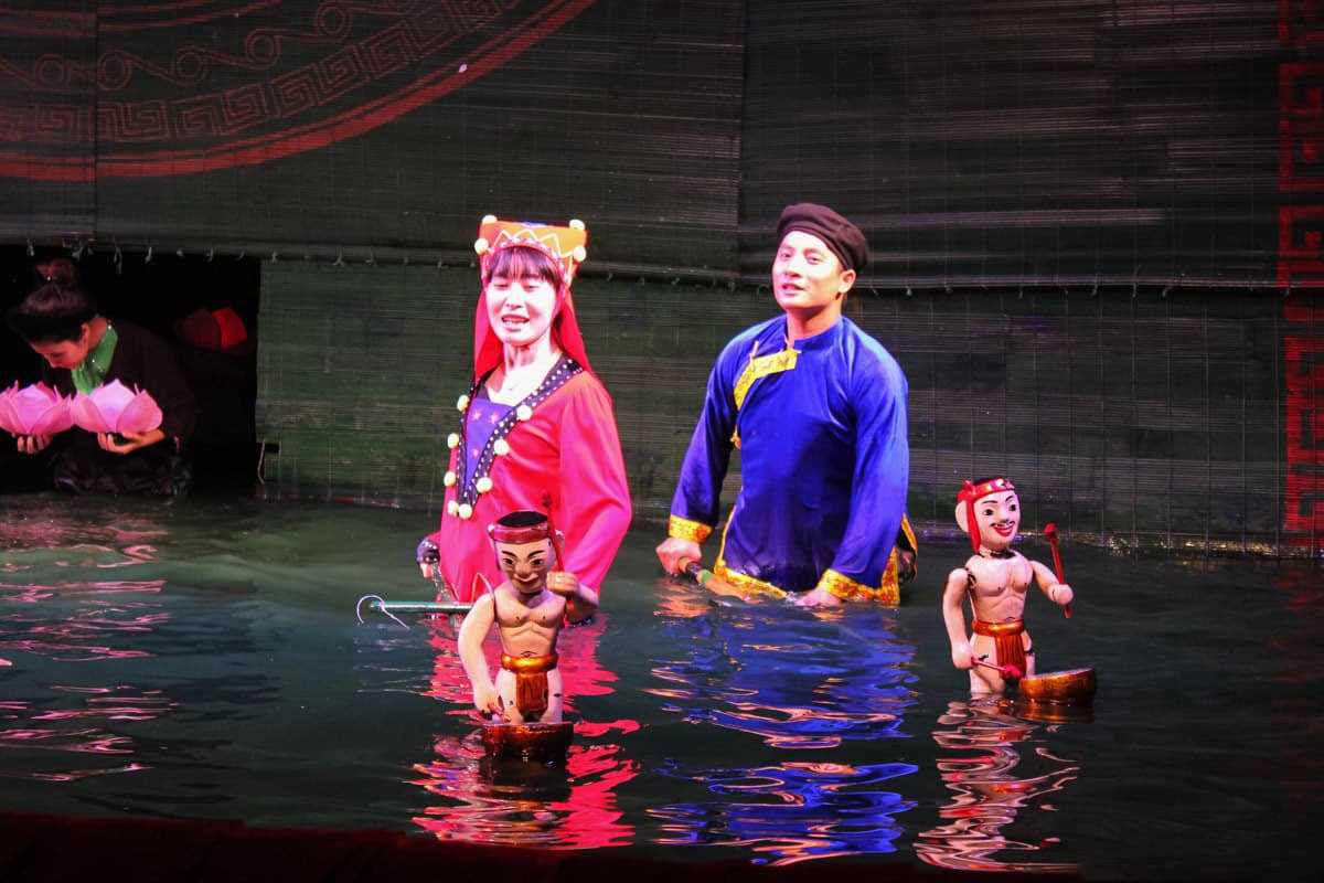 Puppeteer Controlling Water Puppet Characters Puppeteers controlling traditional water puppets dressed in colorful costumes during the show
