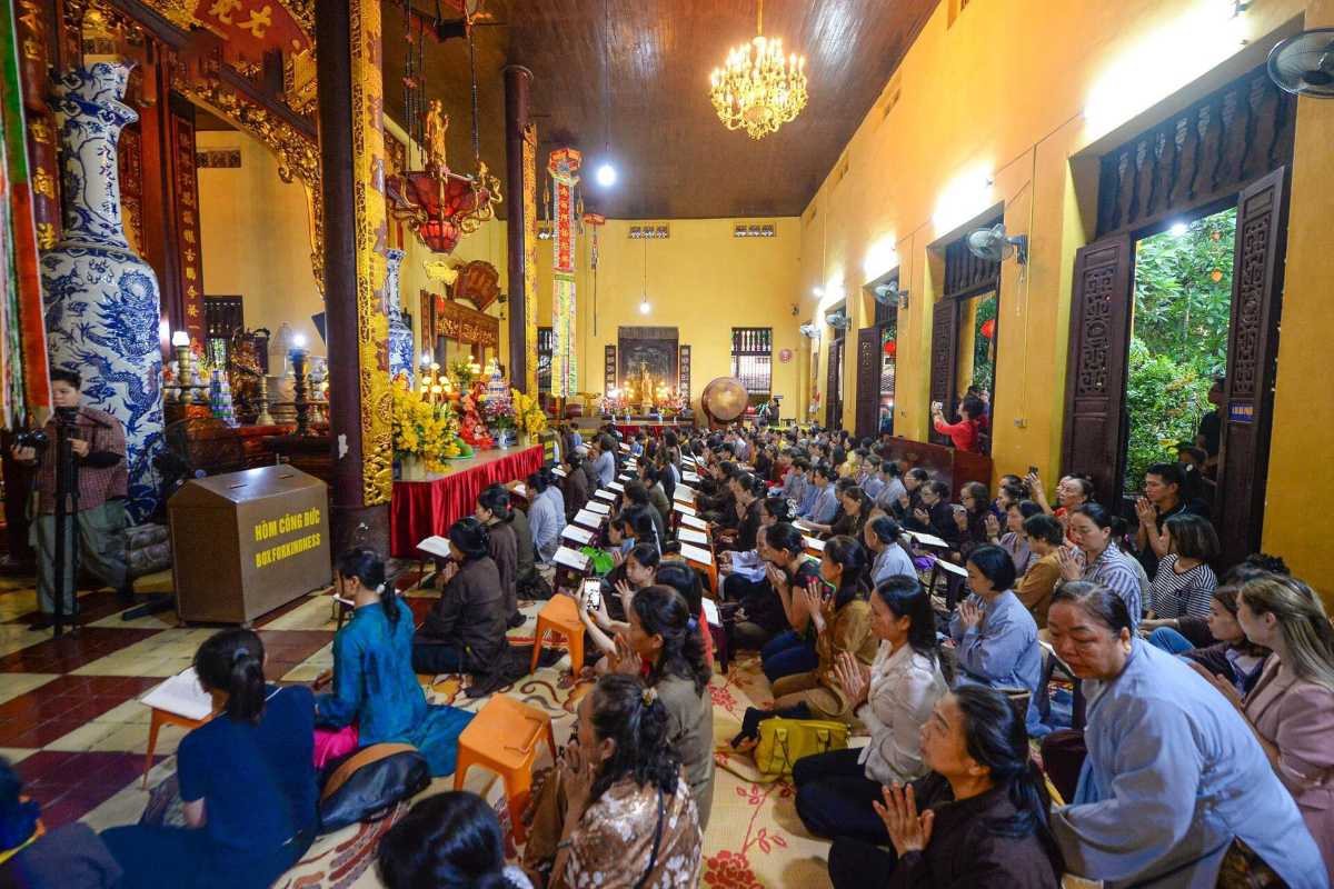 Devotees at Main Altar in Quan Su Pagoda Hanoi Worshippers paying respects at the main altar adorned with flowers and offerings