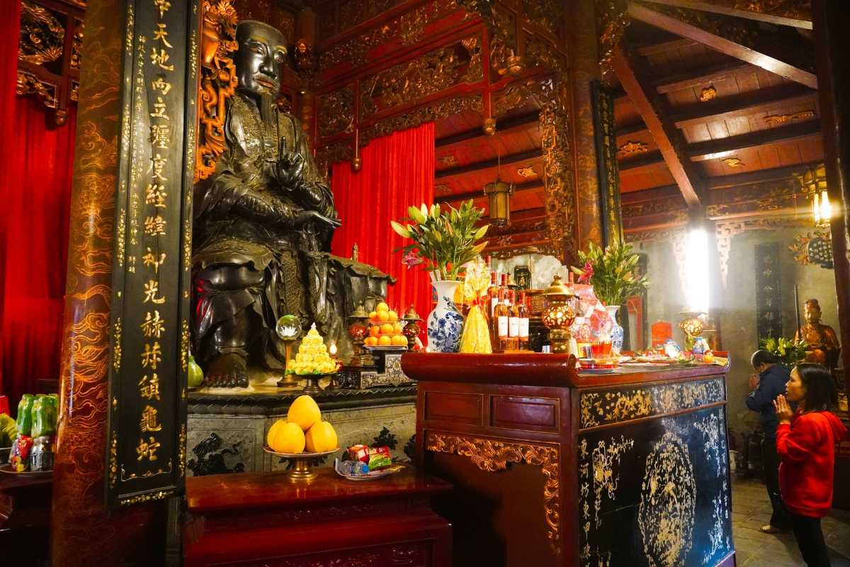 Quan Thanh Temple Visitors Praying Inside Visitors praying inside the richly decorated interior of Quan Thanh Temple