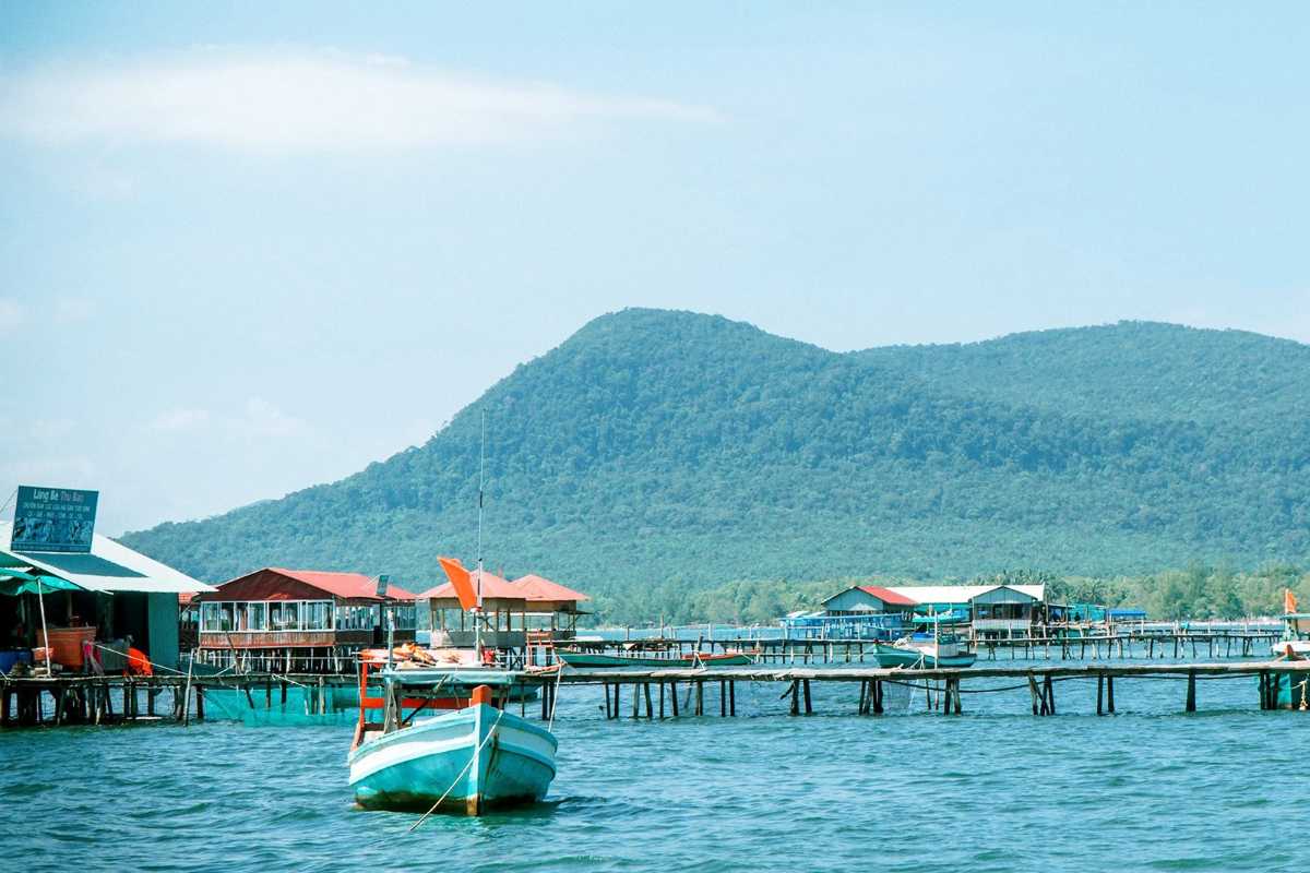 Calm Evening Sea with Wooden Pier at Rach Vem Evening calm sea reflecting wooden pier and fishing boats at Rach Vem, Phu Quoc
