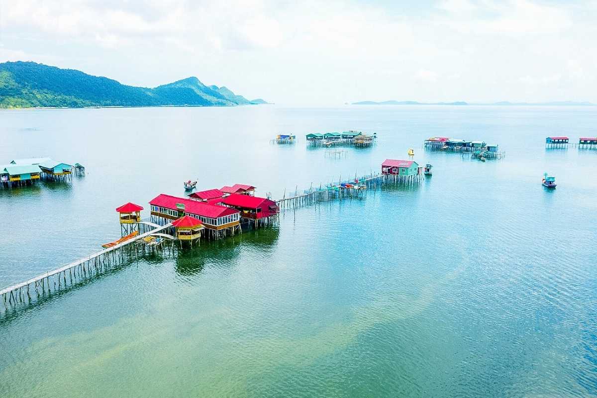Sunrise at Rach Vem Fishing Village with wooden pier extending over calm coastal waters in Phu Quoc