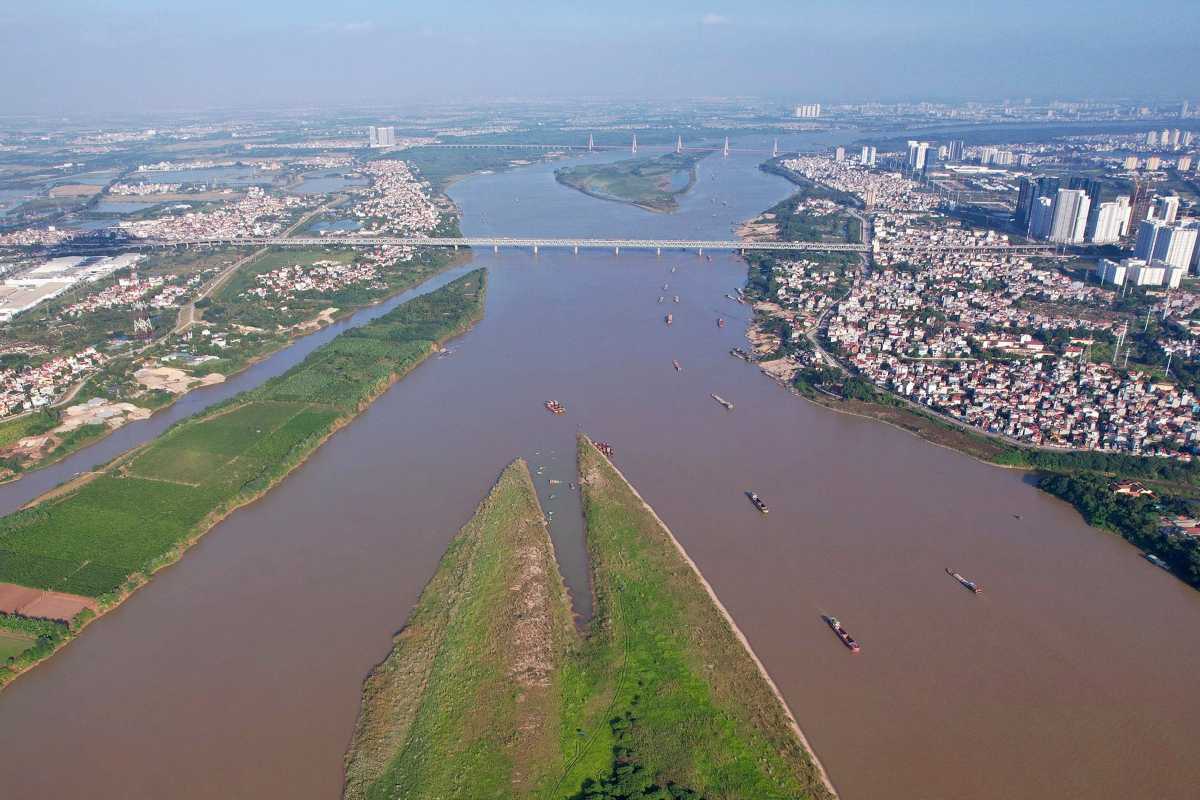 Rusted Bridge Over the Red River Vietnam Old rusted iron bridge over the Red River Vietnam with surrounding greenery