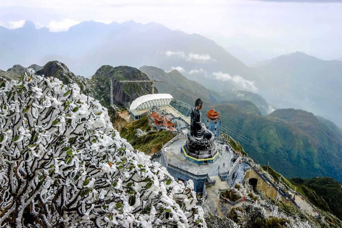 Sapa Heaven Gate Fansipan summit Buddha and snowy landscape Fansipan summit Buddha statue surrounded by snow at Sapa Heaven Gate with panoramic mountain background