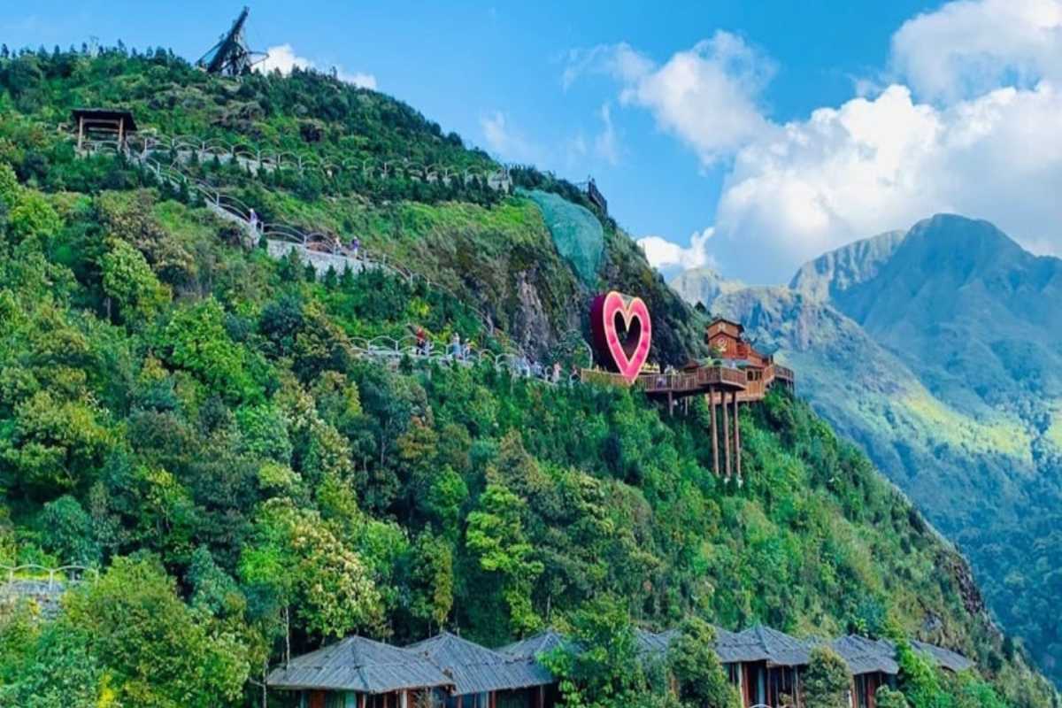 Sapa Heaven Gate hillside heart symbol and forest landscape Heart-shaped sculpture and wooden houses dot the lush hillside at Sapa Heaven Gate with mountain backdrop