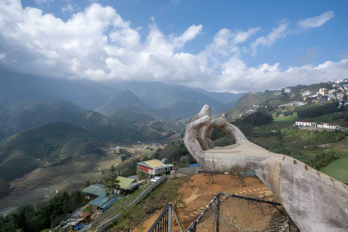 Sapa Heaven Gate Vietnam iconic hand sculpture viewpoint Sapa Heaven Gate hand-shaped viewpoint overlooks Hoang Lien Son mountains and Sapa valley under blue sky