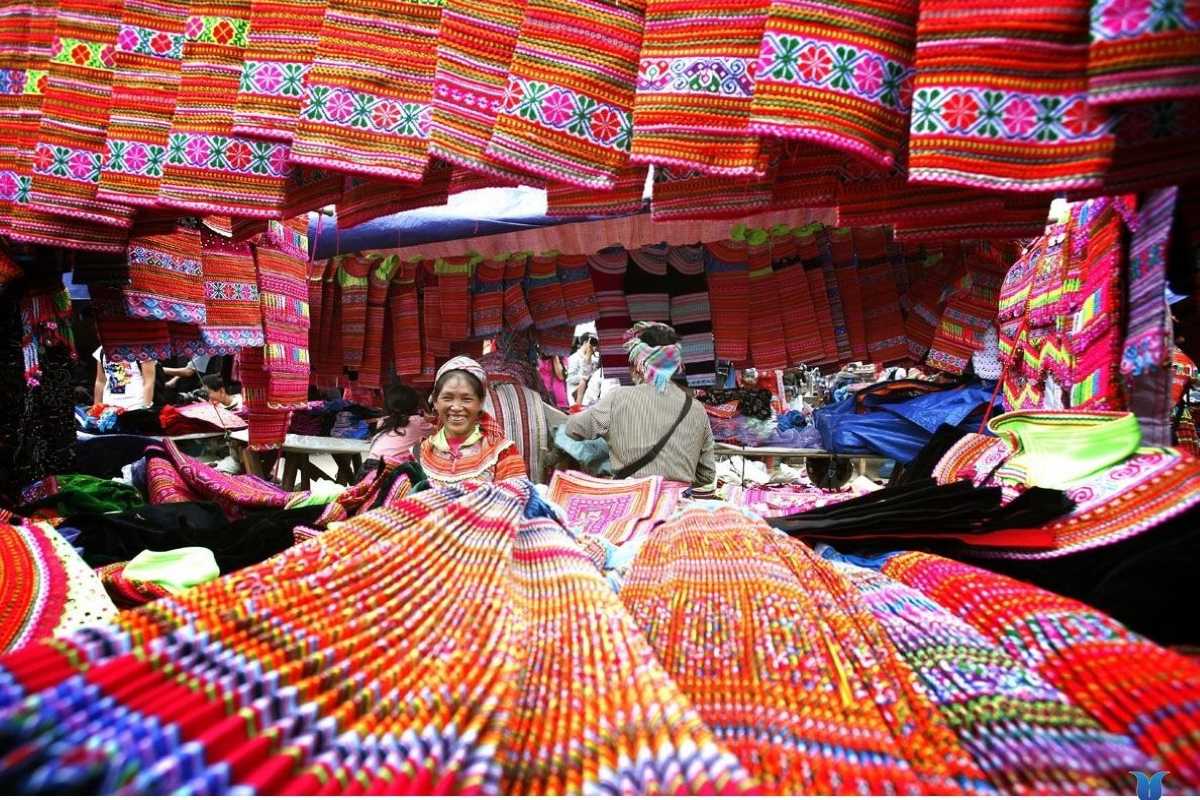 Sapa Love Market colorful textiles and fabrics for sale at local vendor stalls Sapa Love Market is filled with vibrant textiles, patterned fabrics, and smiling vendors offering unique handmade goods in Sapa.