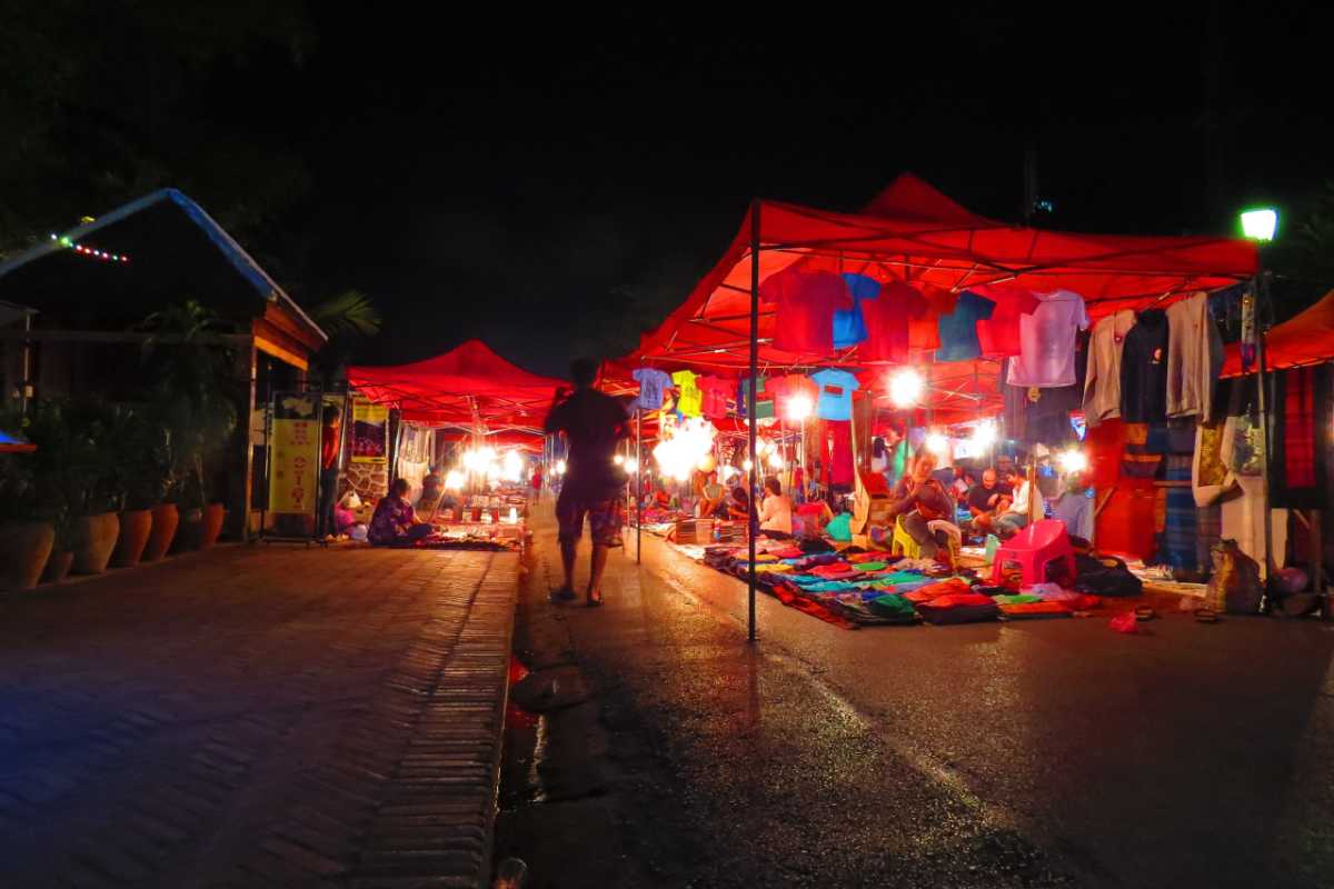 Sapa Love Market night street with red tents and local vendors Sapa Love Market in Sapa displays red tents and illuminated night market stalls selling colorful clothing and local products.