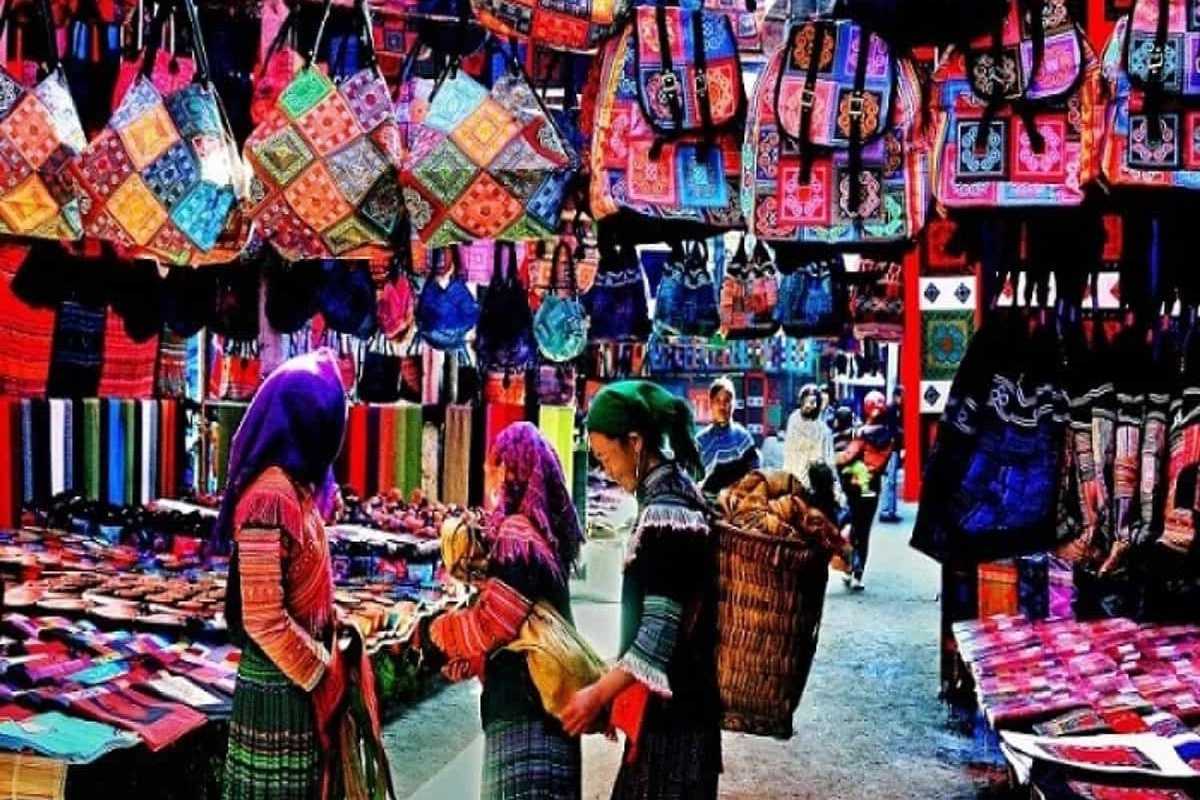 Sapa Love Market Vietnam traditional handicraft stalls Sapa Love Market Vietnam features local women browsing colorful textile handicraft stalls and handmade bags.