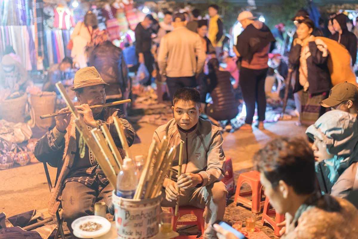 Sapa Love Market Vietnam local musicians and flutes Sapa Love Market Vietnam captures local musicians playing flutes and bamboo instruments during the lively night market.