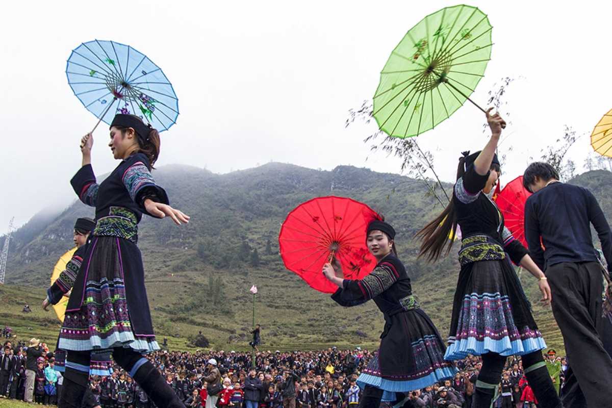 Sapa Love Market Vietnam colorful umbrella dance Sapa Love Market Vietnam parade displays women in ethnic dress performing a traditional umbrella dance outdoors.