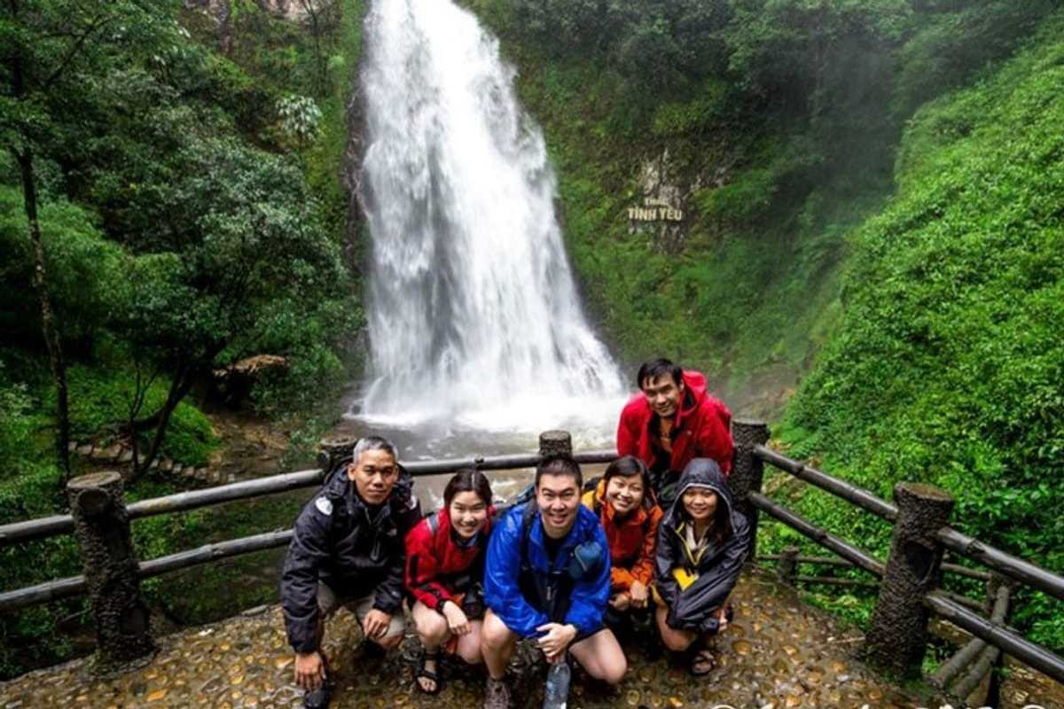 Sapa Love Waterfall main cascade group photo spot Sapa Love Waterfall powerful cascade forms a dramatic backdrop as a smiling group of visitors poses on the viewing platform
