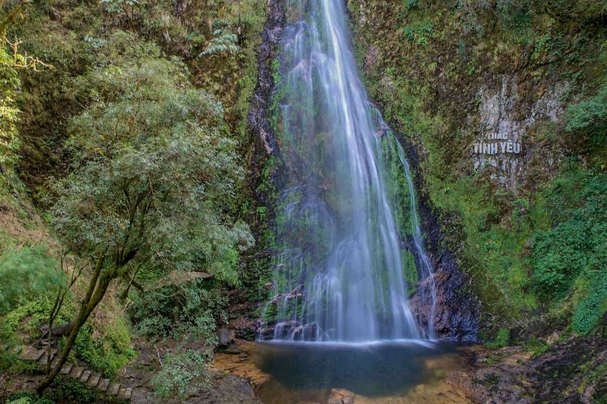 Sapa Love Waterfall tranquil cascade main pool Sapa Love Waterfall’s main cascade plunges into a tranquil pool, bordered by mossy rocks and forest in Sapa, Vietnam.