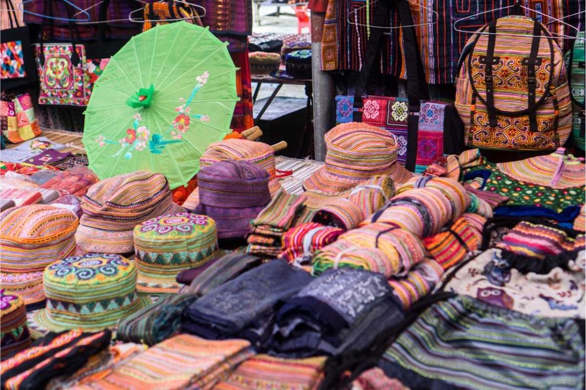 Sapa Night Market Night Vendors and Local Handicrafts Vendors sitting beside their handmade handicrafts and textiles under lights at night in Sapa Night Market.