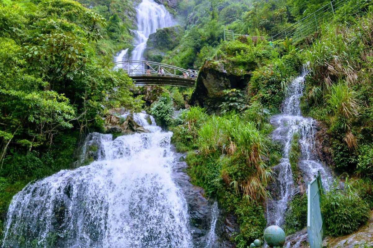Silver Waterfall Sapa vibrant summer greens Silver Waterfall Sapa is surrounded by lush green foliage in summer, highlighting the waterfall’s natural beauty.
