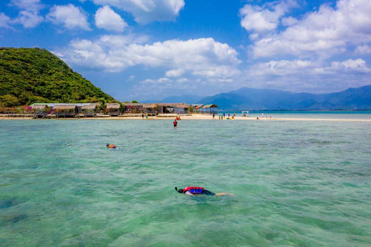Snorkeling and swimming near Thi Island Snorkeler swimming in shallow turquoise waters near Thi Island Nha Trang’s sandy shore